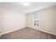 A bedroom with neutral-colored walls and carpet with a window at 4477 James Wade Dr, Snellville, GA 30039