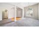 Open-concept living room with neutral carpet, and chandelier at 4477 James Wade Dr, Snellville, GA 30039