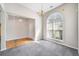 Bright living room features large window, gray carpet, hardwood entry, and elegant chandelier at 4477 James Wade Dr, Snellville, GA 30039