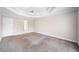 Spacious carpeted main bedroom featuring a tray ceiling and a ceiling fan at 4477 James Wade Dr, Snellville, GA 30039