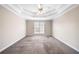 Spacious carpeted main bedroom featuring a tray ceiling and a ceiling fan at 4477 James Wade Dr, Snellville, GA 30039