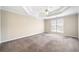 Spacious carpeted main bedroom featuring a tray ceiling and a ceiling fan at 4477 James Wade Dr, Snellville, GA 30039
