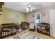 Bedroom with three cribs, neutral paint, and a sitting area at 3521 Stone Ridge Dr, Douglasville, GA 30134