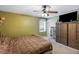 Olive bedroom featuring a ceiling fan, large tv, and plenty of storage at 3521 Stone Ridge Dr, Douglasville, GA 30134