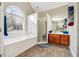 Bright bathroom featuring a large arched window, soaking tub, and separate glass shower at 429 Telluride Ct, Locust Grove, GA 30248