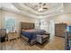 Bedroom showcasing a stylish tray ceiling, plank flooring, and elegant furnishings at 429 Telluride Ct, Locust Grove, GA 30248