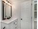 Modern bathroom with a black framed mirror, white cabinets, and stylish fixtures at 125 Warren Ne St, Atlanta, GA 30317