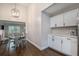 Open dining area with large windows, decorative lighting, and white kitchen at 125 Warren Ne St, Atlanta, GA 30317