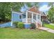 Inviting exterior view of a blue home featuring a classic front porch and well-manicured lawn at 125 Warren Ne St, Atlanta, GA 30317