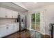 Bright kitchen with stainless steel appliances, white cabinetry, and access to a backyard deck at 125 Warren Ne St, Atlanta, GA 30317