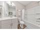 Bright bathroom featuring white cabinets, quartz countertops, and a tub with a shower at 124 Redford Ln, Canton, GA 30115