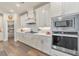 Gourmet kitchen boasts stainless steel appliances, white cabinetry, and a walk-in pantry at 124 Redford Ln, Canton, GA 30115