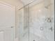 Bright bathroom showcasing a glass-enclosed shower featuring marble tiling and a built-in bench at 124 Redford Ln, Canton, GA 30115