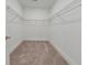 Well-lit empty walk-in closet featuring neutral carpeting and built-in shelving for optimal storage at 124 Redford Ln, Canton, GA 30115