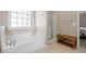This bathroom features a soaking tub, tile floors, and a glass shower at 1656 Maes Overlook, Loganville, GA 30052
