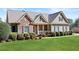 Charming home featuring stone accents, green siding, lush lawn, and well-maintained landscaping at 1656 Maes Overlook, Loganville, GA 30052