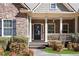 Inviting front porch entrance featuring stone accents, columns, and a decorative front door at 1656 Maes Overlook, Loganville, GA 30052