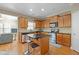 The kitchen features an island with seating, wooden cabinetry, and stainless steel appliances at 1656 Maes Overlook, Loganville, GA 30052