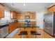 A spacious kitchen with stainless steel appliances, a kitchen island, and wooden cabinetry at 1656 Maes Overlook, Loganville, GA 30052