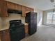 Kitchen with wood cabinets, black appliances, and adjacent dining area at 916 Hunt Rd, Jonesboro, GA 30236
