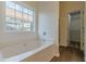 Bright bathroom features a large window, large bathtub and entrance to the closet at 239 Gilliam Ct, Locust Grove, GA 30248