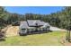 Expansive aerial view showcases this home's large lot, inviting exterior, and charming barn set amongst a lush forest backdrop at 2925 Old Broadnax Mill Rd, Loganville, GA 30052