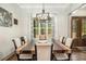 A dining room featuring a wooden table, modern light fixture, and natural light from a large window at 2925 Old Broadnax Mill Rd, Loganville, GA 30052