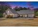 Exterior of the home at dusk, with a covered porch and outdoor seating at 2925 Old Broadnax Mill Rd, Loganville, GA 30052