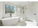 Bright bathroom featuring a modern tub, frameless glass shower, and large window at 439 Wind Walk Cir, Lawrenceville, GA 30044
