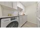 Clean kitchen with white cabinets, subway tile backsplash, and modern appliances including washer and dryer at 1135 Clairemont Ave # B, Decatur, GA 30030