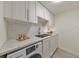 Well-lit laundry area featuring a white marble countertop, white cabinets, and a modern washing machine at 1135 Clairemont Ave # B, Decatur, GA 30030