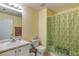 Bright bathroom with a decorative shower curtain, single vanity and neutral tile flooring at 4150 Soaring Dr, Douglasville, GA 30135