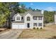 Charming two-story home featuring a two-car garage, classic architectural details, and mature trees at 4150 Soaring Dr, Douglasville, GA 30135