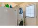 Functional laundry area featuring a stacked washer and dryer, plus extra refrigerator for added convenience at 4150 Soaring Dr, Douglasville, GA 30135