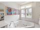 Bathroom with a jetted tub, shutters on the window, and plenty of light at 50 Biscayne Nw Dr # 6117, Atlanta, GA 30309