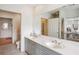 Bright bathroom with double vanity, gray cabinets, marble floors, and large mirror reflecting the bedroom at 50 Biscayne Nw Dr # 6117, Atlanta, GA 30309