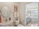 Well-lit bathroom featuring a pedestal sink, toilet, framed art, and a glimpse into the tub/shower combo at 50 Biscayne Nw Dr # 6117, Atlanta, GA 30309