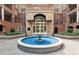 Charming courtyard with a decorative fountain, manicured landscaping, and brick building facade at 50 Biscayne Nw Dr # 6117, Atlanta, GA 30309