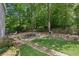Charming backyard featuring a stone patio with outdoor seating, mature trees, and a stone pathway at 750 Crest Valley Nw Dr, Sandy Springs, GA 30327