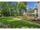 Spacious backyard showcasing lush green lawn, stone pathways, a patio area, and beautiful landscaping at 750 Crest Valley Nw Dr, Sandy Springs, GA 30327