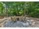 Fire pit area featuring gravel ground cover, a ringed fire pit, and rustic wooden seating at 750 Crest Valley Nw Dr, Sandy Springs, GA 30327
