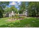 Large backyard with well-maintained lawn, stone patio, mature trees, and an inviting outdoor living space at 750 Crest Valley Nw Dr, Sandy Springs, GA 30327