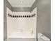 Clean, white tiled bathroom with a combination tub and shower at 750 Crest Valley Nw Dr, Sandy Springs, GA 30327