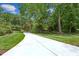 Long driveway leading to a home surrounded by mature trees and a well-maintained lawn at 750 Crest Valley Nw Dr, Sandy Springs, GA 30327