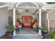 Charming front porch with a red door, decorative columns, and comfortable seating at 750 Crest Valley Nw Dr, Sandy Springs, GA 30327