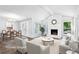 Bright living room with stone fireplace, white couches, and dining area view at 750 Crest Valley Nw Dr, Sandy Springs, GA 30327