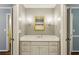 Charming powder room with a white vanity, decorative mirror, and elegant sconces at 750 Crest Valley Nw Dr, Sandy Springs, GA 30327