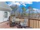 Outdoor deck with seating, a stained wood deck, and a view of the wooded backyard and blue skies at , Auburn, GA 30011