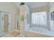 Elegant bathroom with garden tub, glass shower, and crisp white finishes at , Auburn, GA 30011