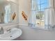 Charming powder room with wainscoting, white sink, and decorative window treatments at , Auburn, GA 30011